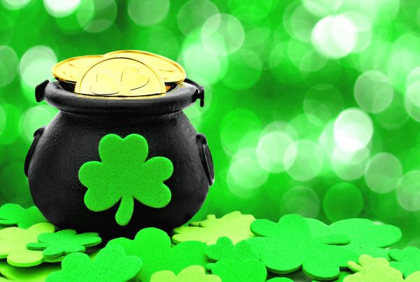 st patricks day pot of gold and shamrocks over a green background